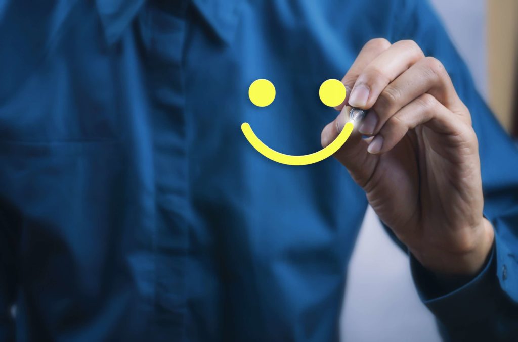 Digital experience manager draws a smiling face on the glass